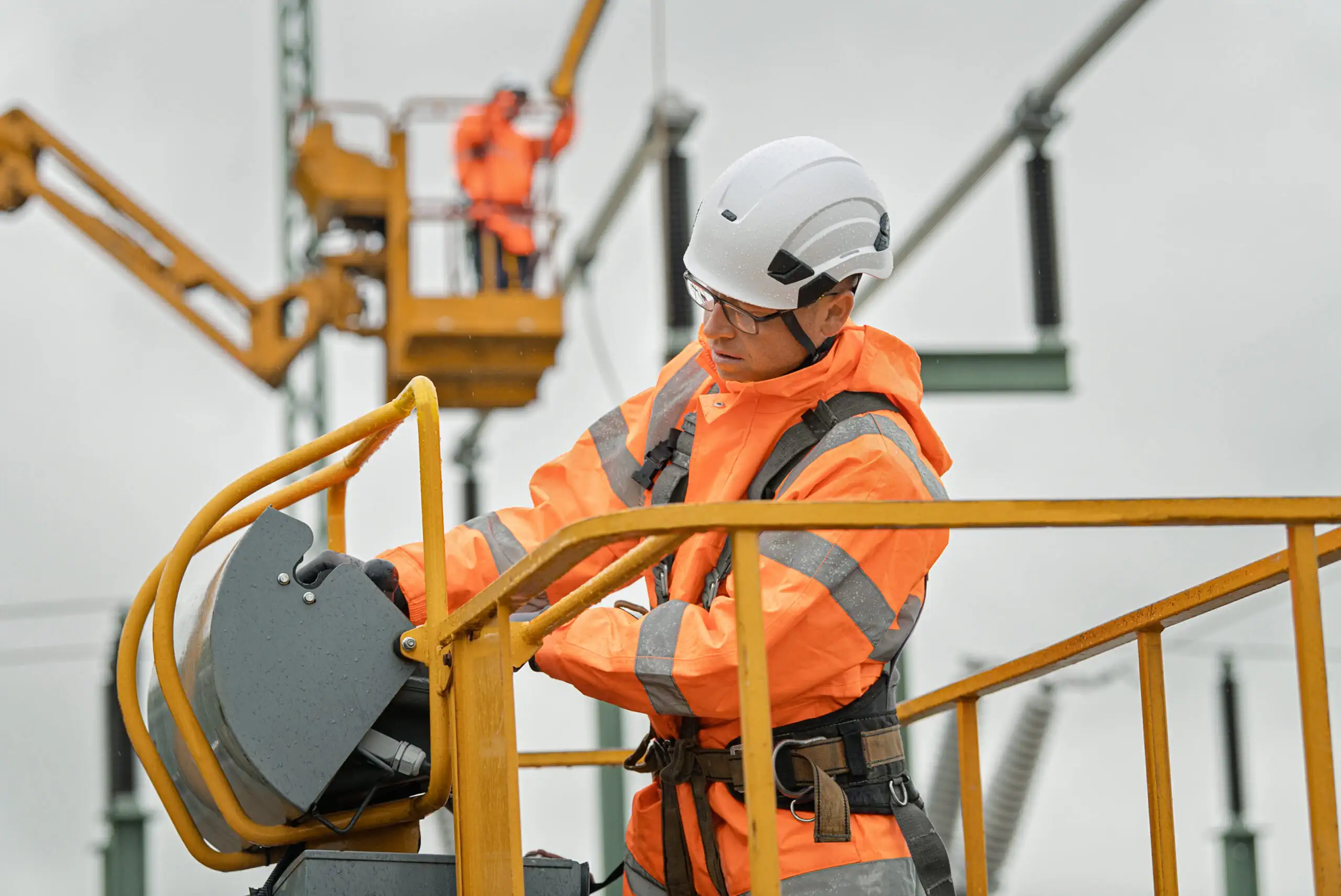 Ein Mann arbeitet an einer Hochspannungsleitung.